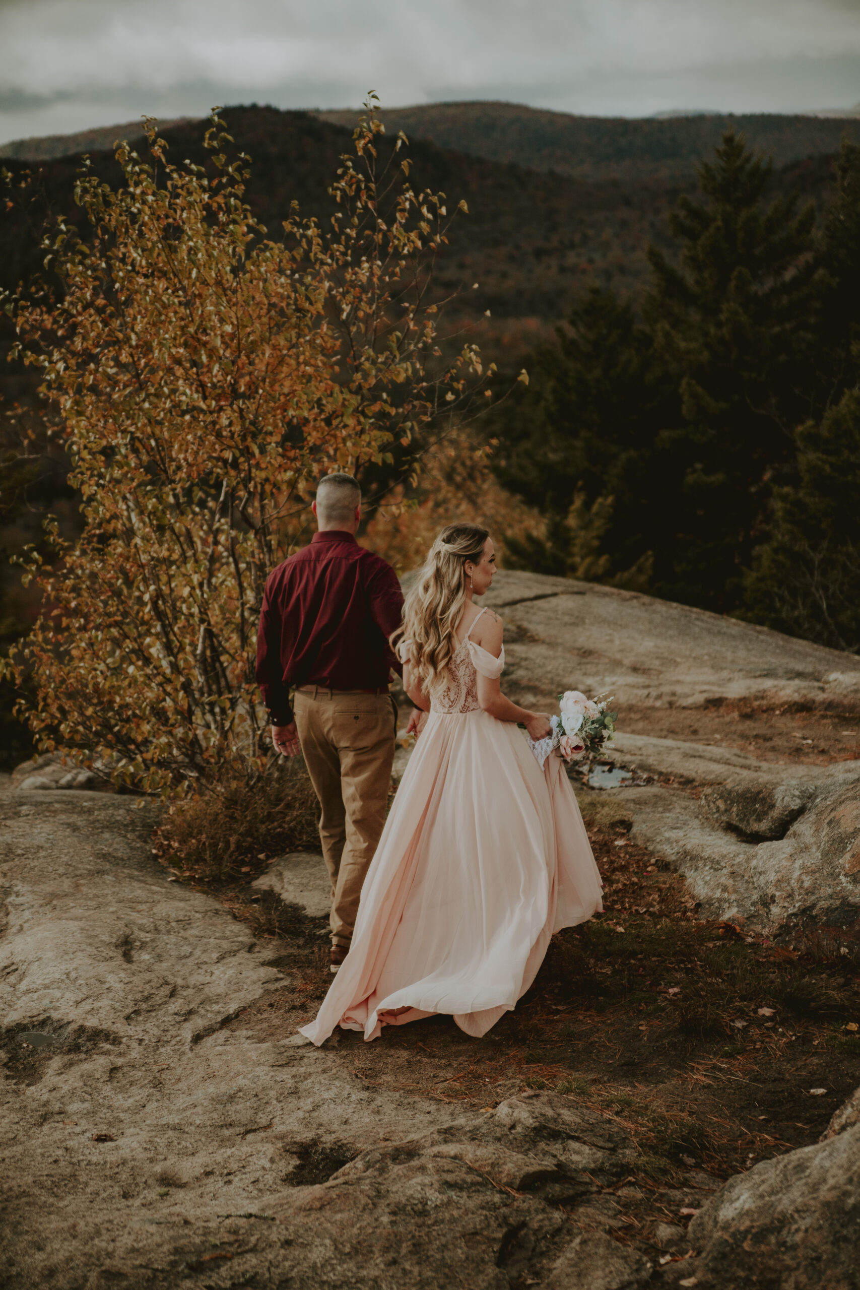 Couple walking on rocky mountain summit