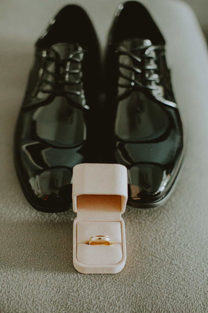 Simple styled, black shoes and wedding band in pink box